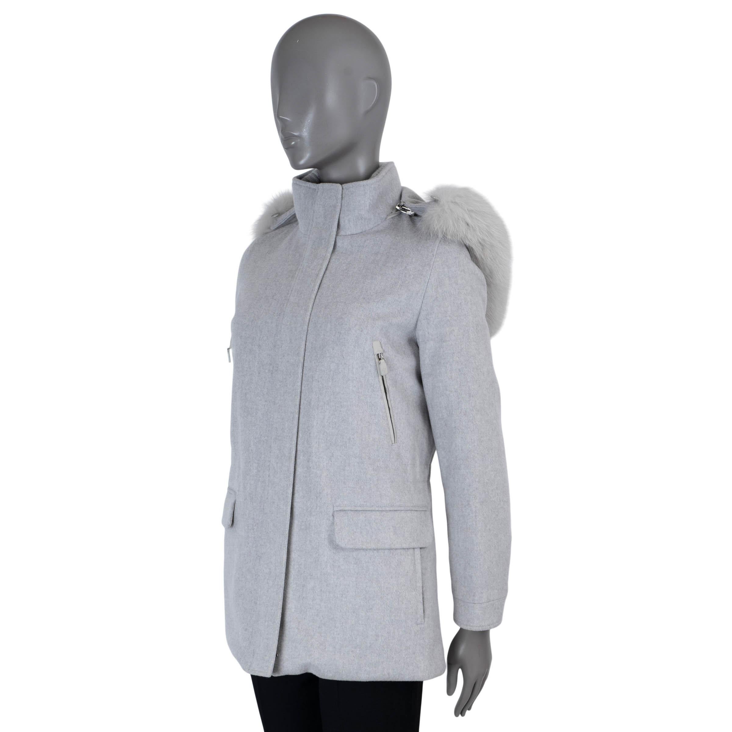 This 100% authentic Loro Piana Klein short parka in light grey Storm System cashmere offers luxurious weather protection. Featuring a hood with dyed fox fur trim, an internal drawstring waist, and two zip and two flap pockets on the front, this