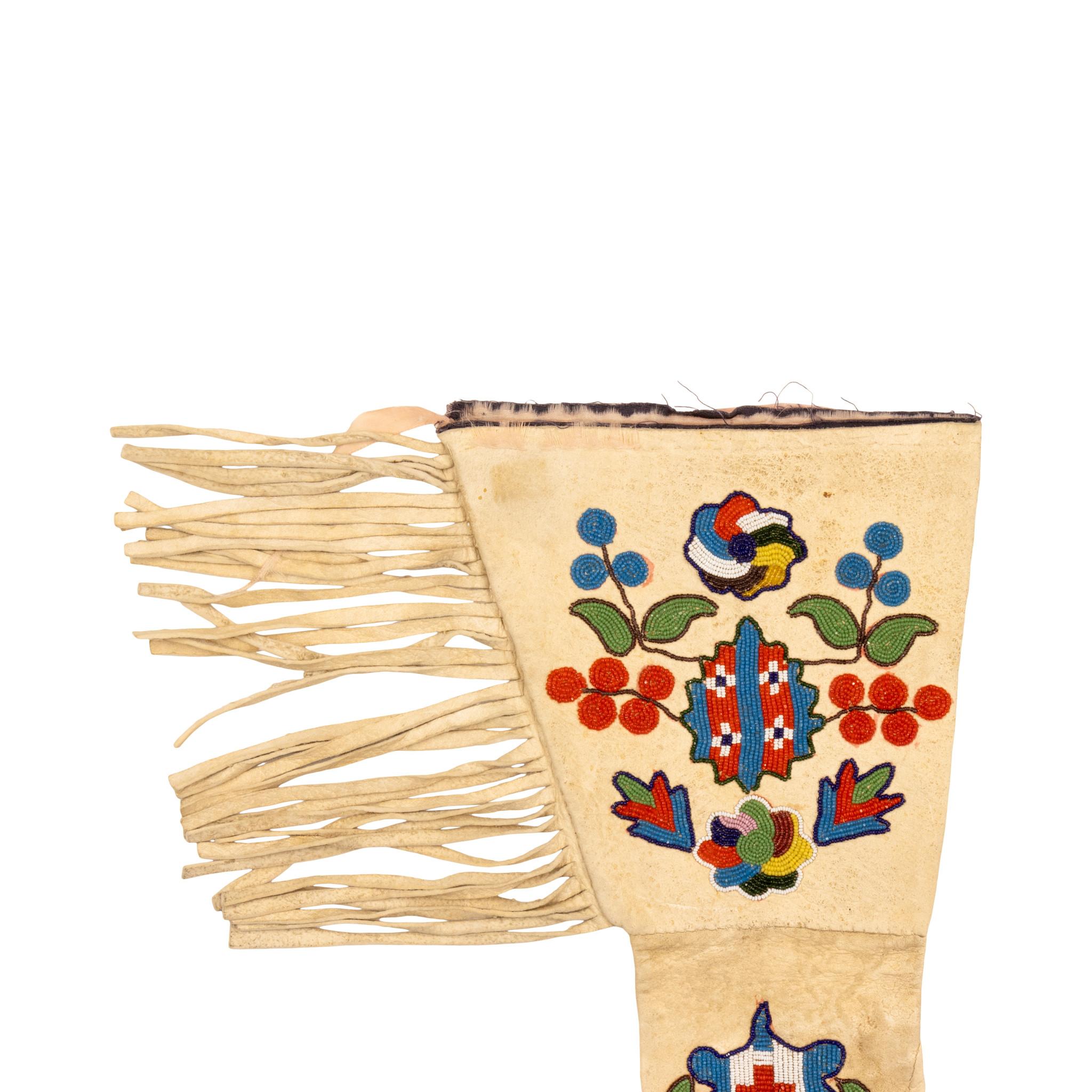 Native American Santee Sioux beaded gauntlets. Striking colorful gauntlets with fringed sides and classic beading on the cuff, hand and fingers. Design features intricate florals on cuffs and crest on hands done with diamonds down fingers. Has